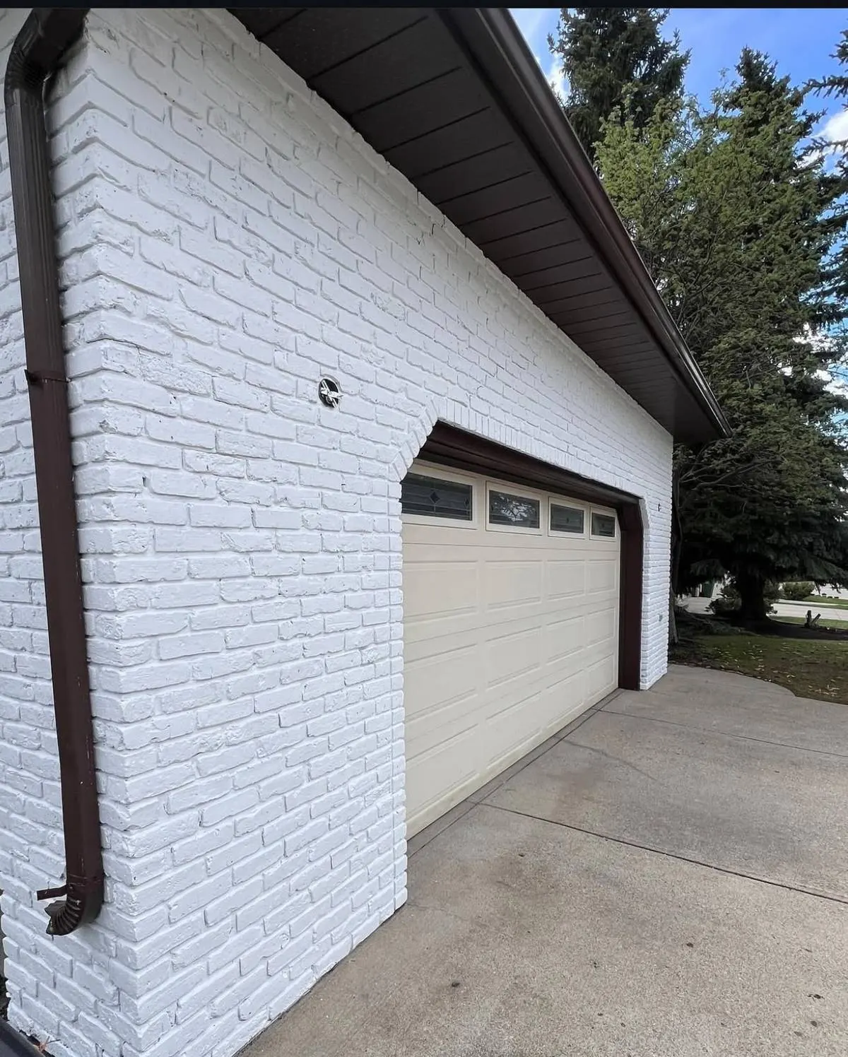 The same garage after painting in white with dark trim and fascia