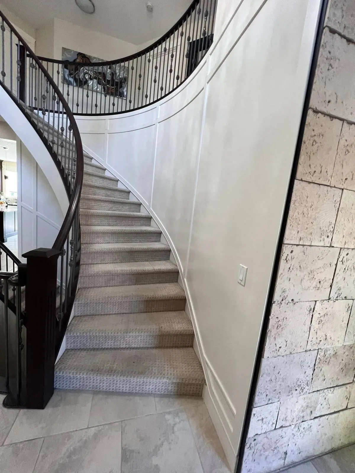 Curved staircase repainted in off-white with panel moulding in the same tone